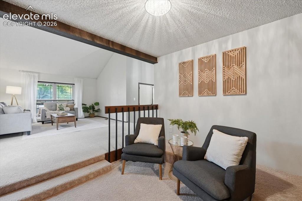Image 12 of 50: Vaulted ceiling, exposed ceiling beam, and wood-finish railing