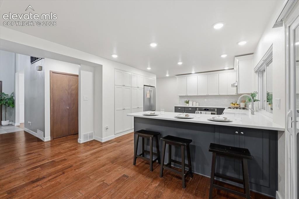 Image 17 of 50: Kitchen featuring wood flooring, recessed lighting, white built in pantry a