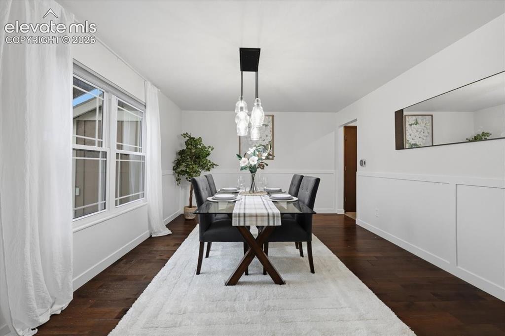 Image 19 of 50: Elegant dining room showcasing dark wood flooring, and custom trim