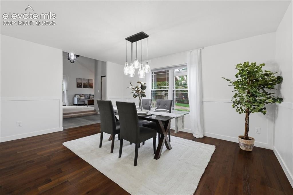 Image 20 of 50: Wood flooring, wainscoting, and a modern rectangular chandelier with clear 