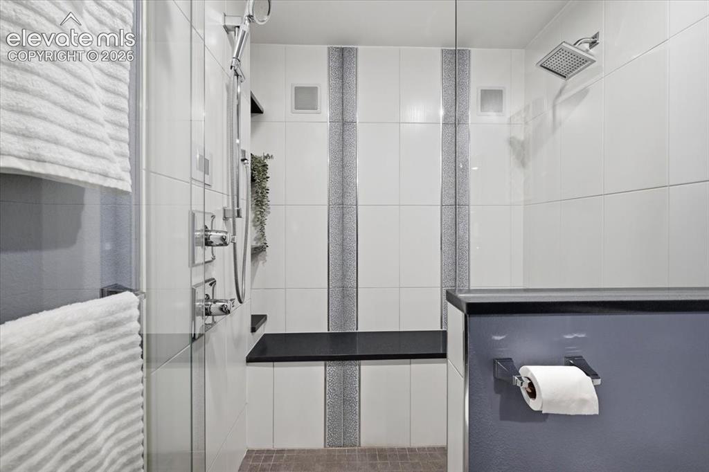 Image 28 of 50: Enclosed Steam Shower with a built-in speakers, dual shower heads, and an i
