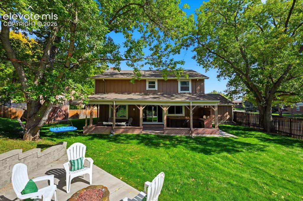 Image 3 of 50: Expansive backyard featuring a manicured lawn, established trees, and a con