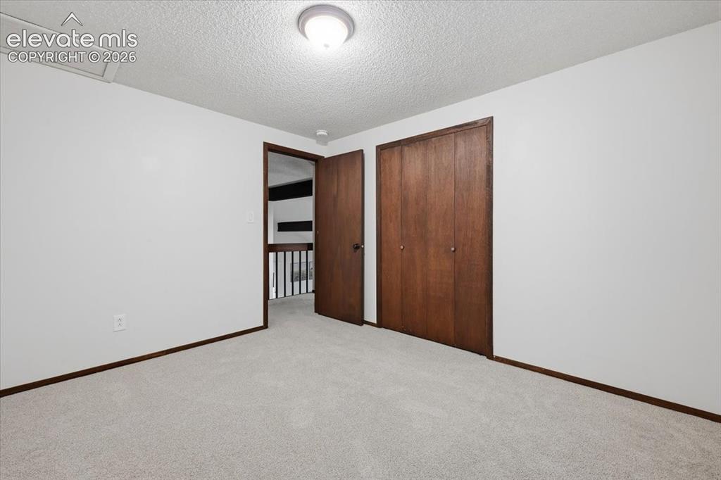 Image 33 of 50: Bedroom 3 - Plush gray carpeting, white walls, and a ceiling-mounted light