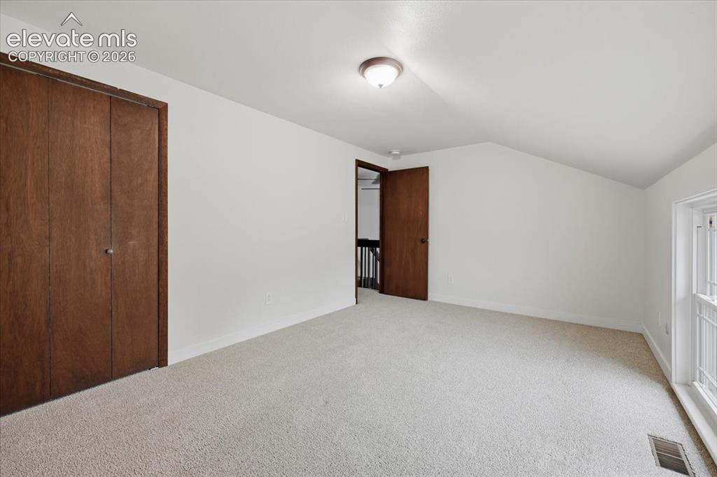 Image 34 of 50: Bedroom 4 - Carpeted room featuring a ceiling-mounted light fixture, sloped