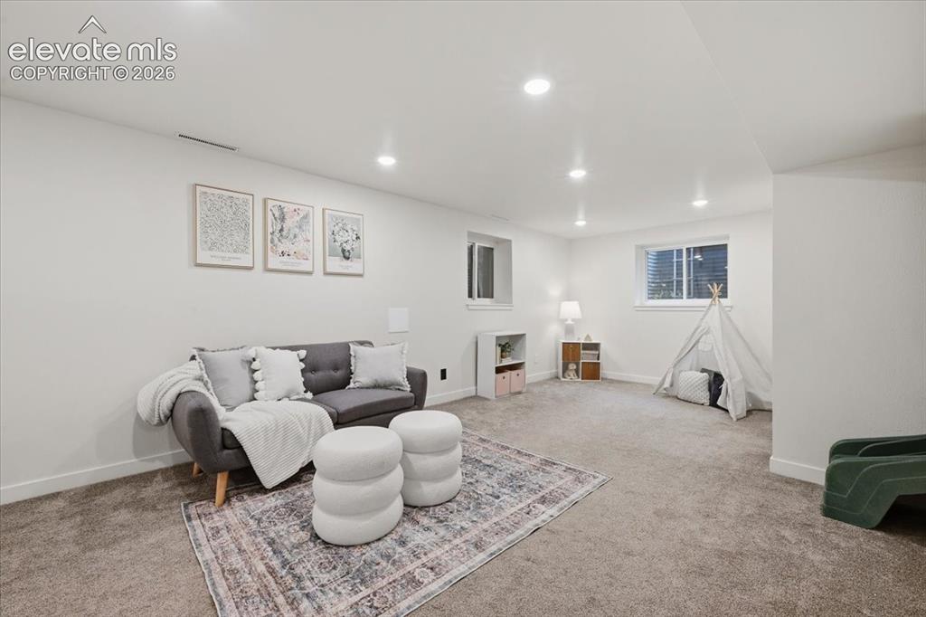 Image 36 of 50: Spacious room with recessed lighting, carpet flooring, and white walls