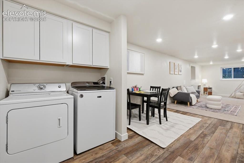 Image 39 of 50: Wood-finish flooring throughout, white upper cabinetry, recessed ceiling li