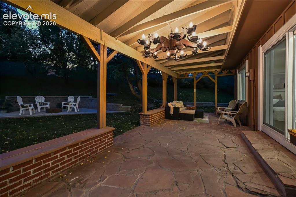 Image 47 of 50: Covered outdoor living area featuring a flagstone patio, exposed beam ceili