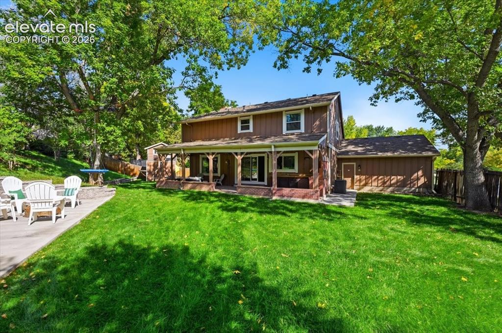 Image 48 of 50: Well manicured lawn with mature trees and a covered patio, Fire pit and pla