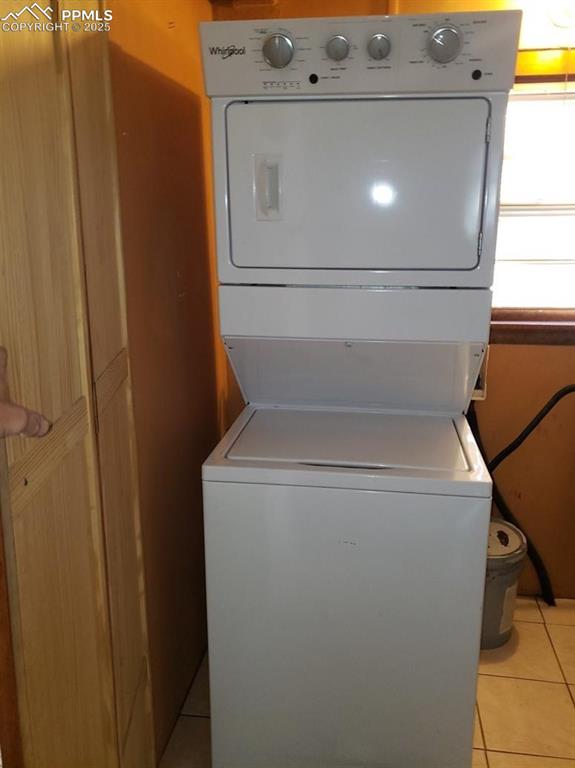 Image 11 of 20: Washroom with light tile patterned flooring, stacked washing maching and dr