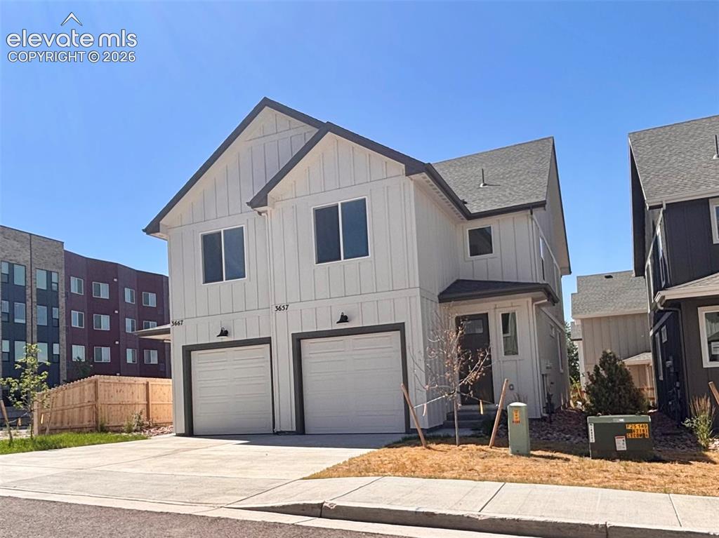 Caption: Modern two-story residence with white vertical siding and dark trim accents