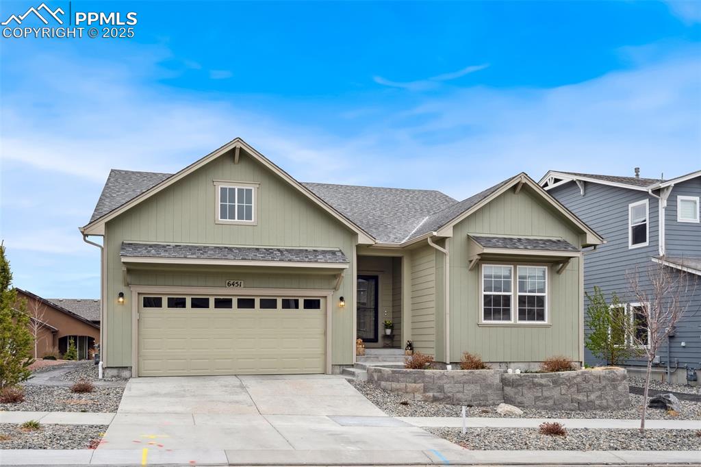 Caption: Single story home with an attached garage, driveway, and a shingled roof