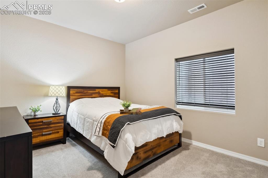Image 29 of 34: Bedroom featuring light colored carpet, baseboards, and visible vents