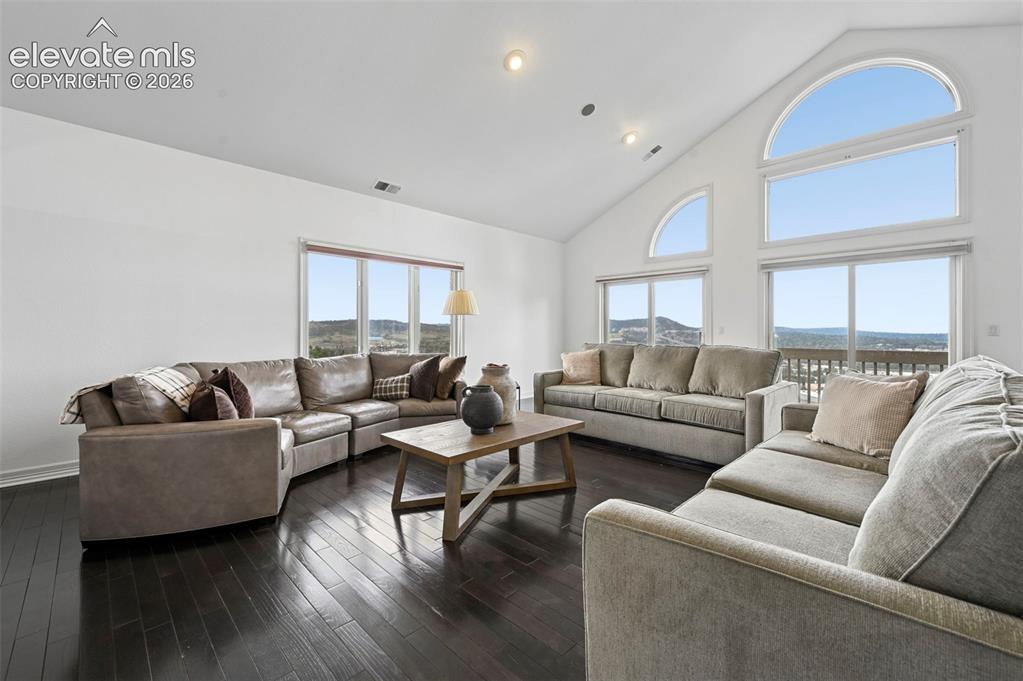 Image 10 of 45: Vaulted ceiling with multiple recessed lights and large arch-top windows
