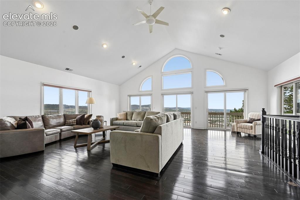 Image 11 of 45: Spacious living area featuring high vaulted ceilings, recessed lighting, da