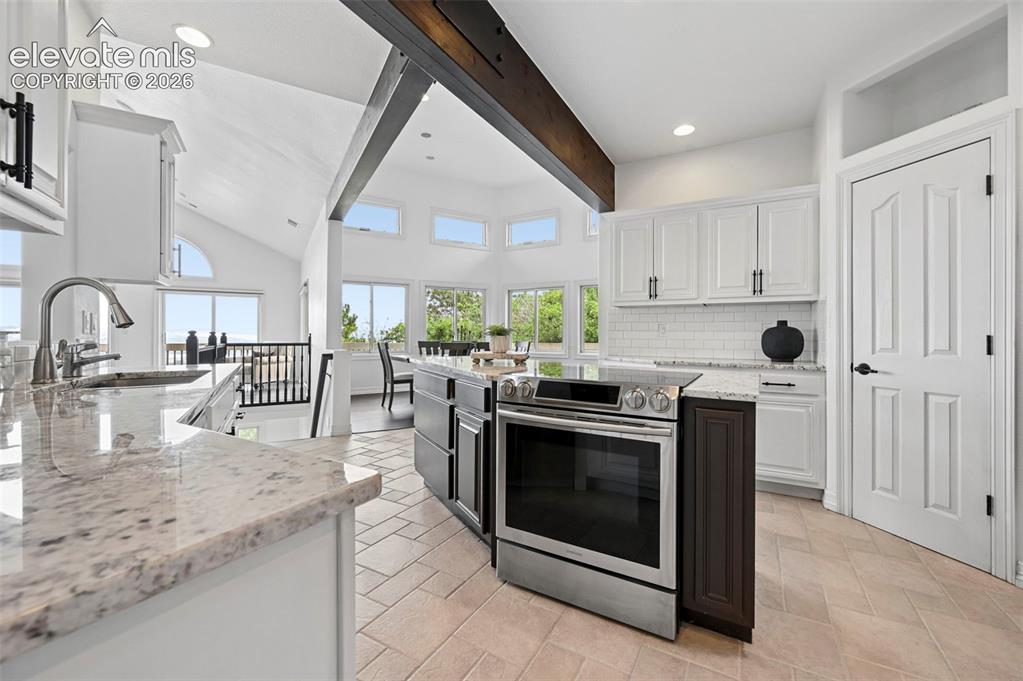 Image 15 of 45: Kitchen featuring a stainless steel range, white shaker-style cabinetry, li