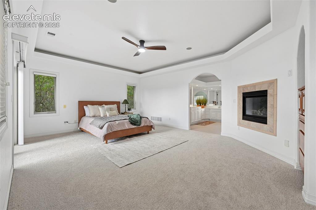 Image 19 of 45: Spacious room featuring light-colored carpeting, a tray ceiling with a ceil