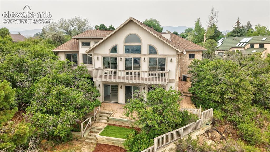 Image 2 of 45: Multi-level residence featuring a prominent arched window and a spacious up