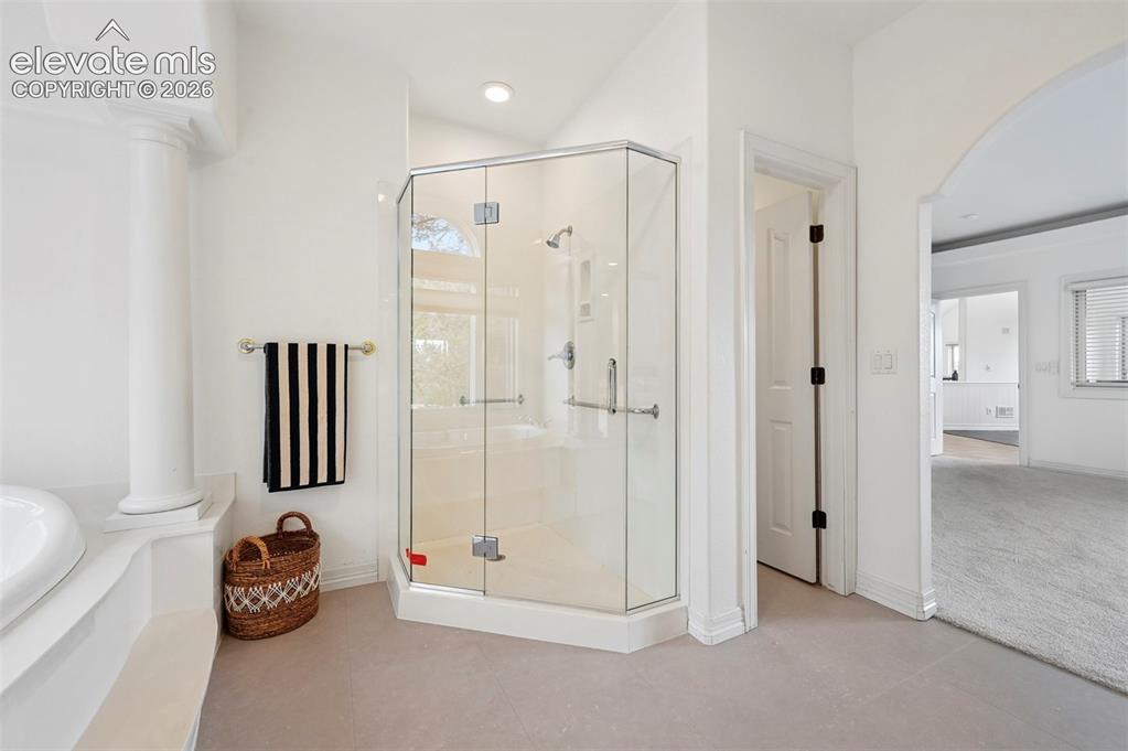 Image 24 of 45: Corner glass-enclosed shower with chrome fixtures
