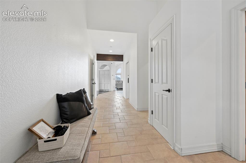 Image 30 of 45: Hallway featuring light-toned tile flooring, recessed lighting, and white p