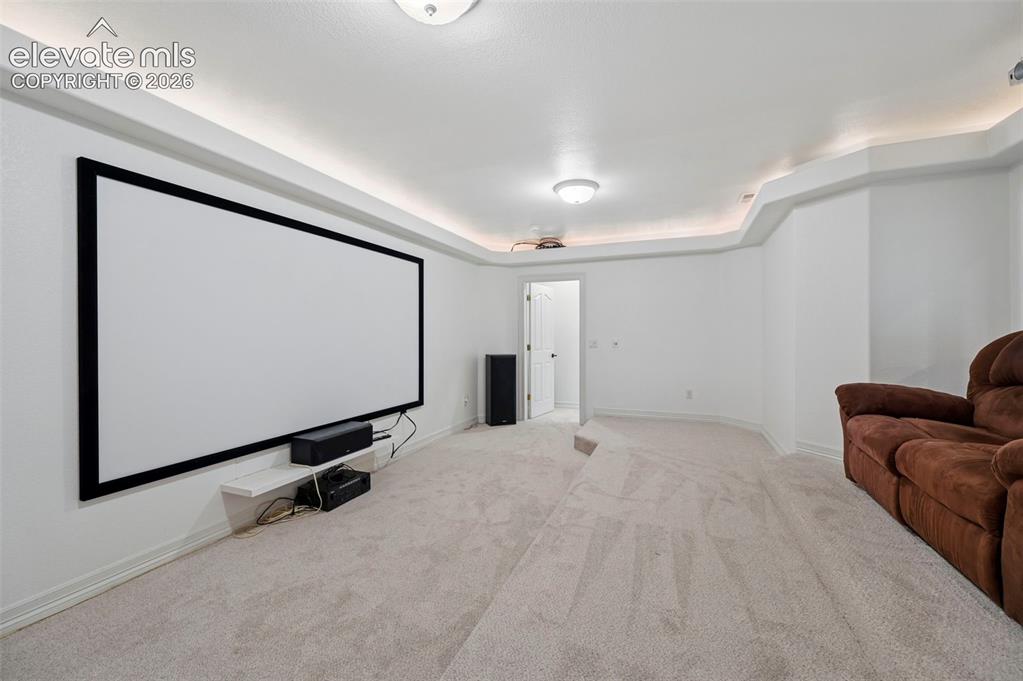 Image 32 of 45: Dedicated media room featuring a large projection screen, recessed ceiling 