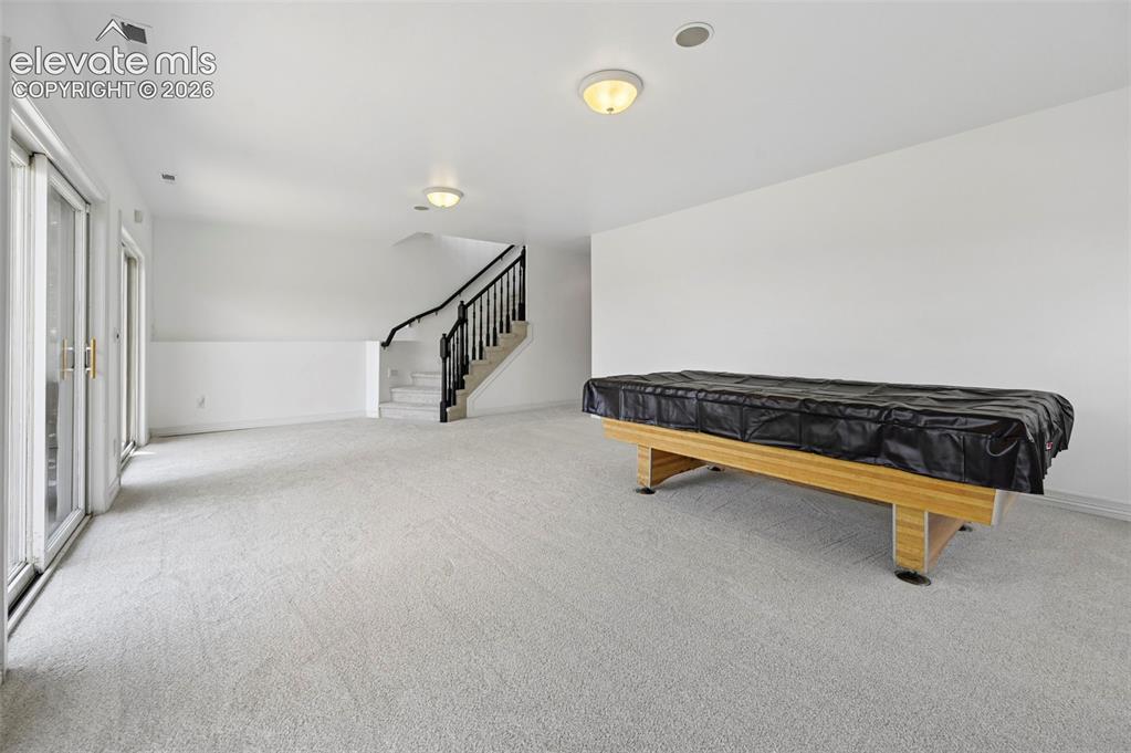 Image 41 of 45: Spacious room featuring light-colored carpeting, white painted walls, and c