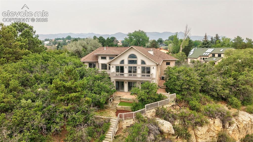 Image 45 of 45: Multi-level residence with extensive natural landscaping and a terraced bac