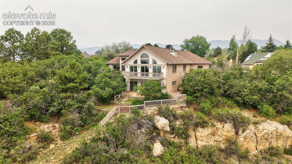 Image 6 of 45: Hillside residence featuring a brick and stucco exterior