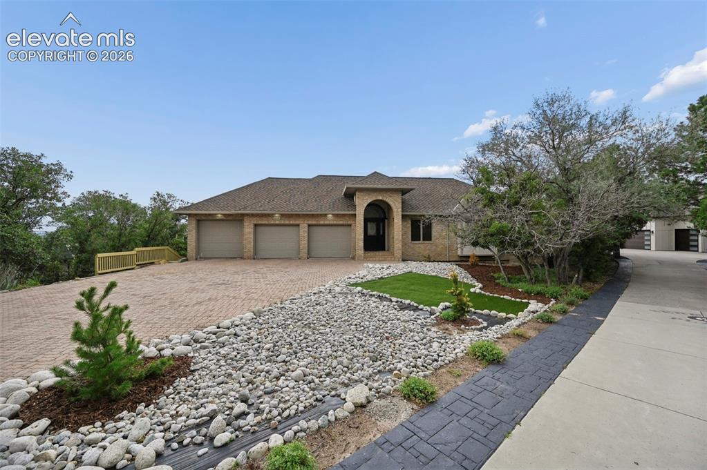 Image 9 of 45: Stunning contemporary residence showcasing a three-car garage with arched a
