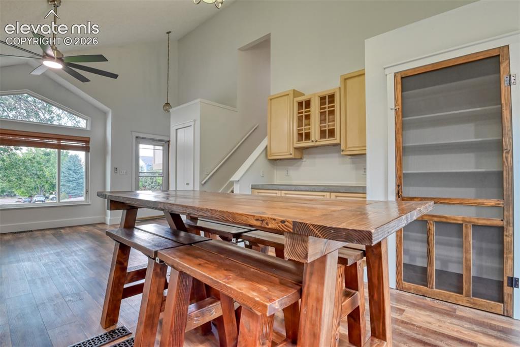 Image 14 of 48: Vaulted ceiling with an overhead fan, large arched window, wood-finish floo