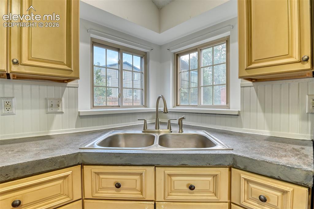 Image 15 of 48: Dual basin stainless steel sink with a brushed nickel faucet, set into a du