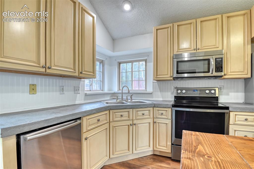 Image 16 of 48: Kitchen featuring light wood cabinetry, stainless steel appliances, a doubl