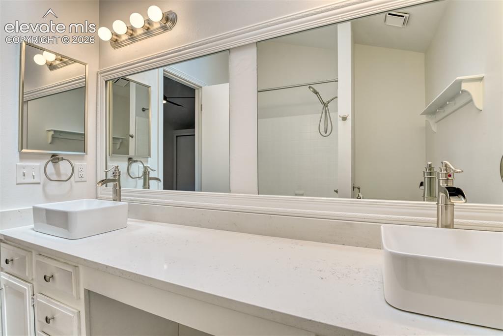 Image 23 of 48: Double vanity with rectangular vessel sinks, extensive countertop space, an