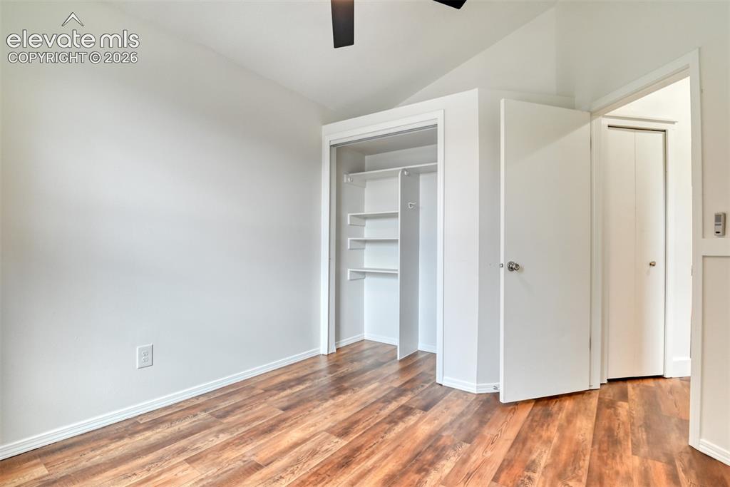 Image 26 of 48: Wood-finish flooring, white walls, and a ceiling fan