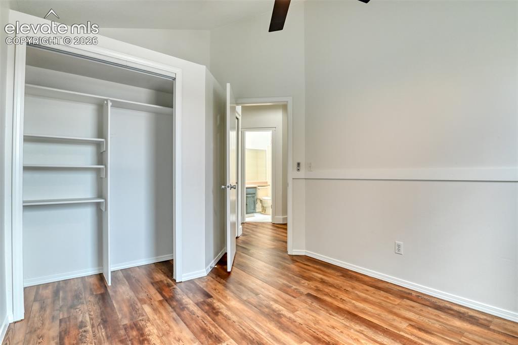 Image 27 of 48: Wood-finish flooring, built-in closet shelving, accent wall trim, and a cei