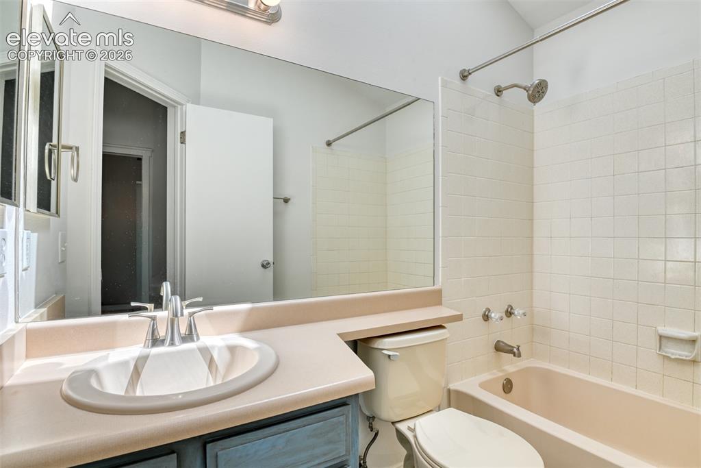 Image 33 of 48: Bathroom vanity with an integrated sink and chrome faucet, large wall mirro