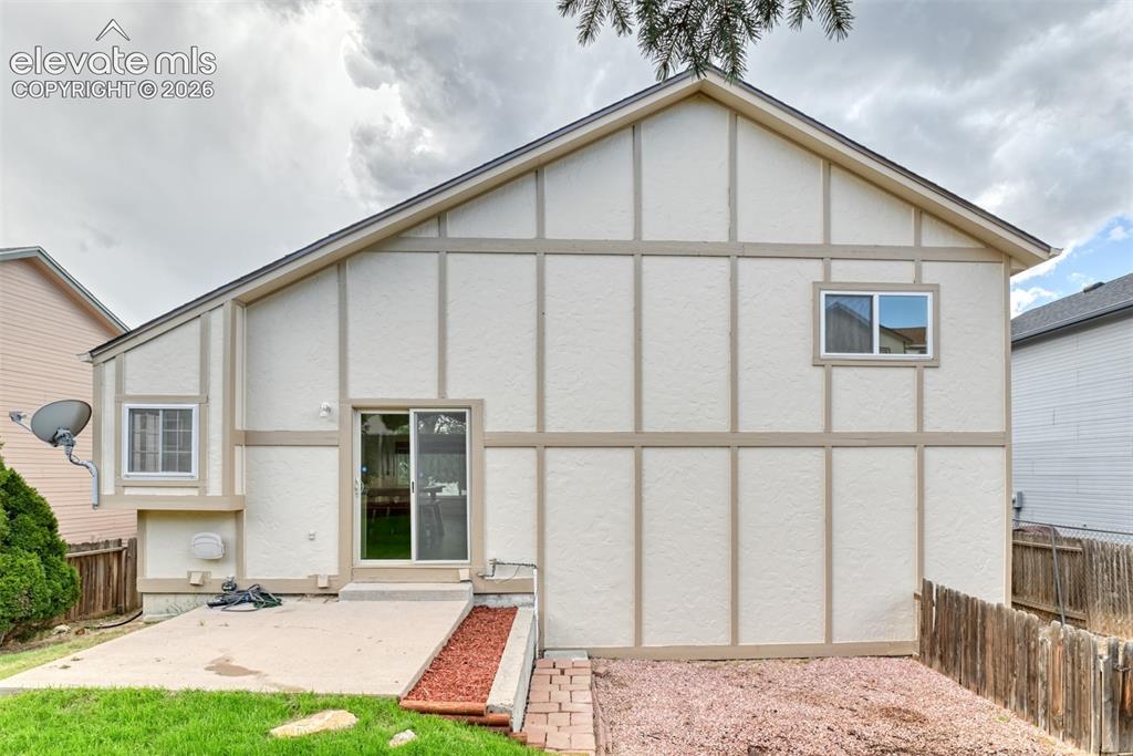 Image 43 of 48: Exterior featuring stucco siding with decorative wood trim, a sliding glass