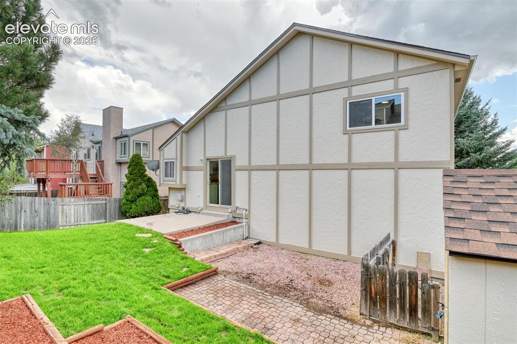 Image 44 of 48: Exterior featuring stucco siding with decorative wood trim, a sliding glass