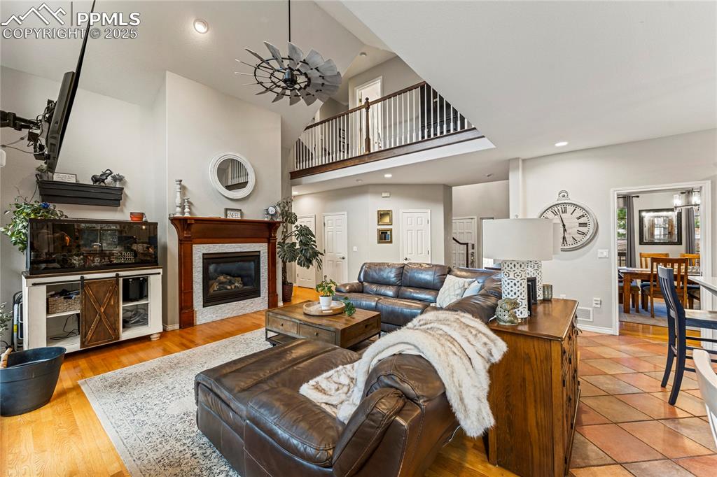 Image 5 of 26: Living area with a glass covered fireplace, wood finished floors, recessed 