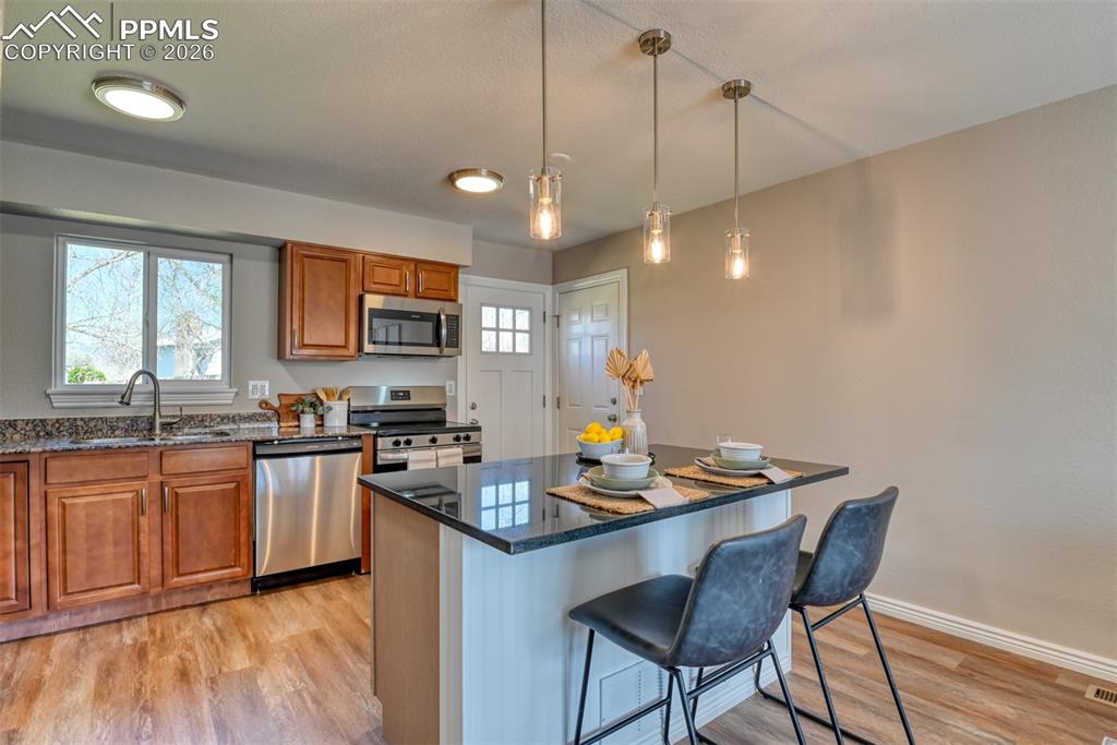 Image 10 of 39: The kitchen features stainless steel appliances, granite countertops, and a