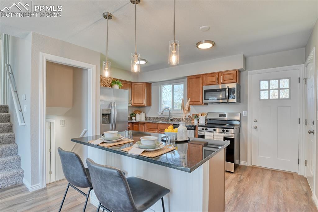 Image 11 of 39: The property features a kitchen with wood cabinetry, stainless steel applia