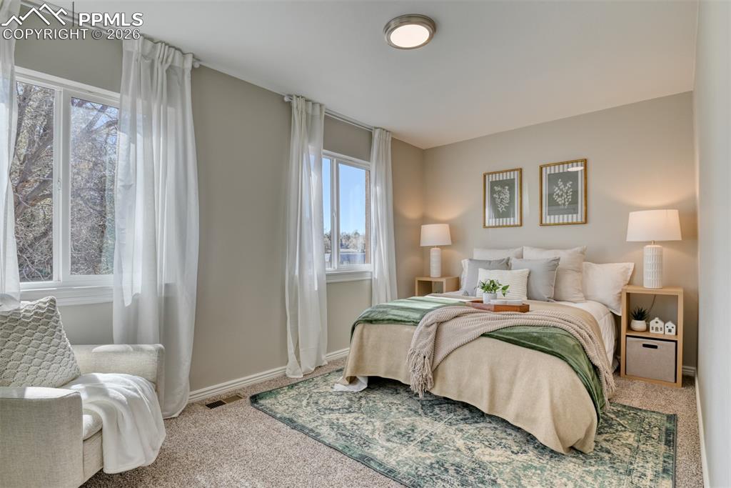 Image 15 of 39: The property features a room with carpeted flooring, light-colored walls, a