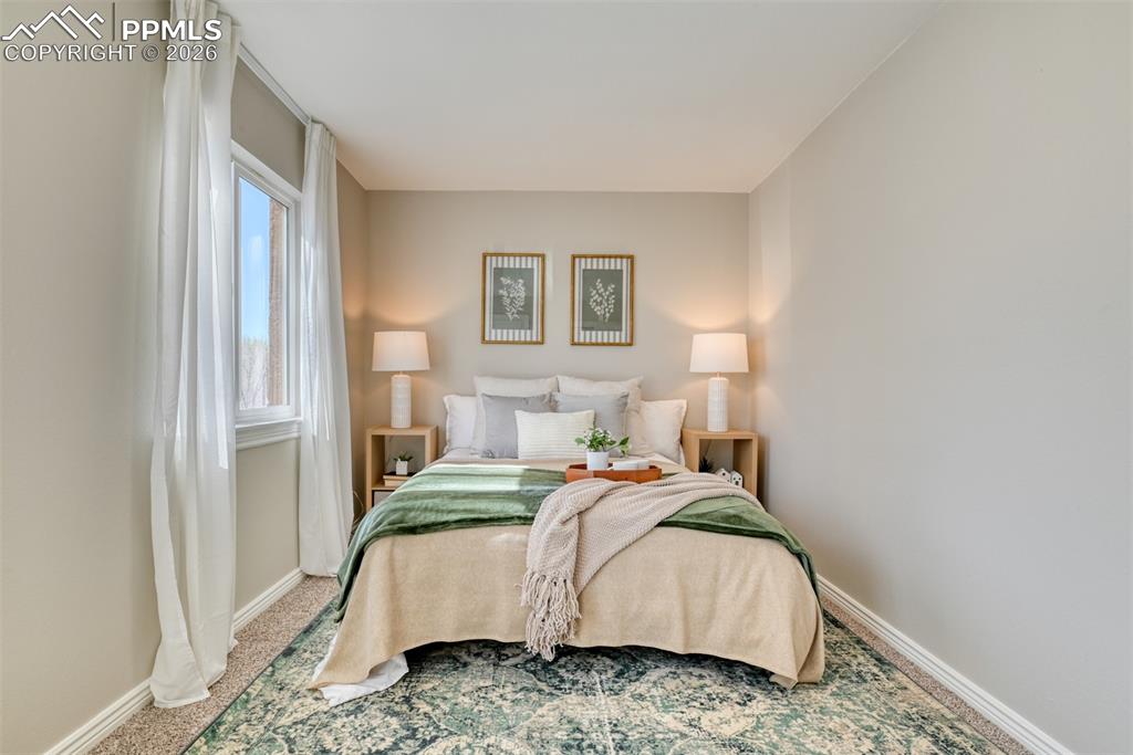 Image 19 of 39: This room features a window with sheer white curtains, wall-to-wall carpeti