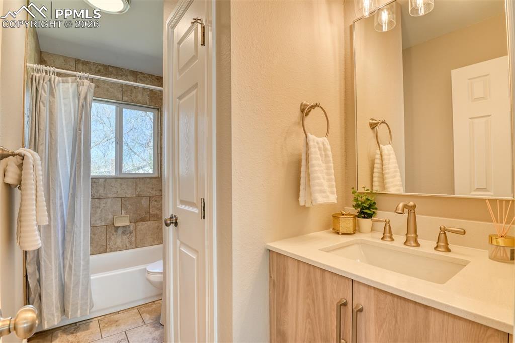 Image 20 of 39: Bathroom featuring a single vanity with a white countertop and a mirror, a