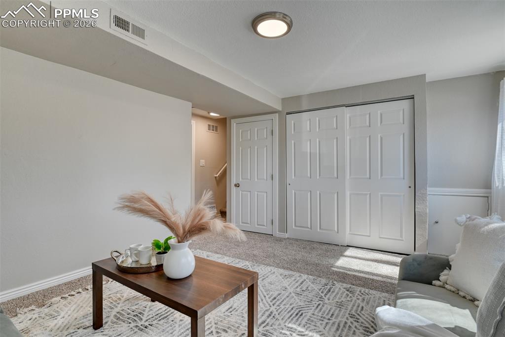 Image 28 of 39: Living space featuring carpet flooring, a light-colored wall, and a light f