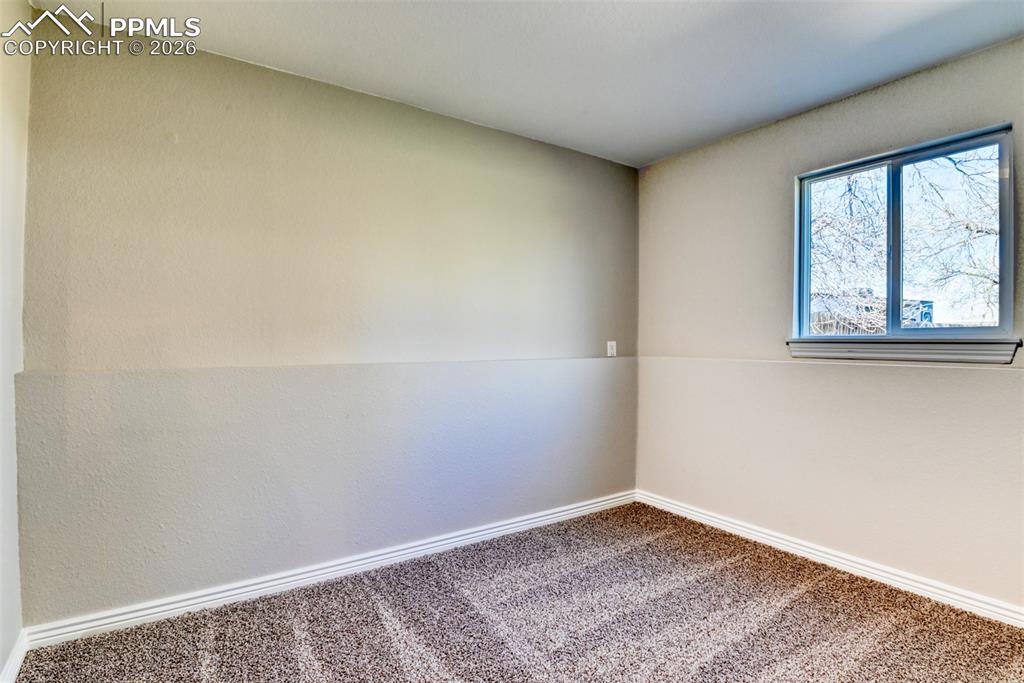 Image 32 of 39: This room features neutral-toned walls, a window providing natural light, a
