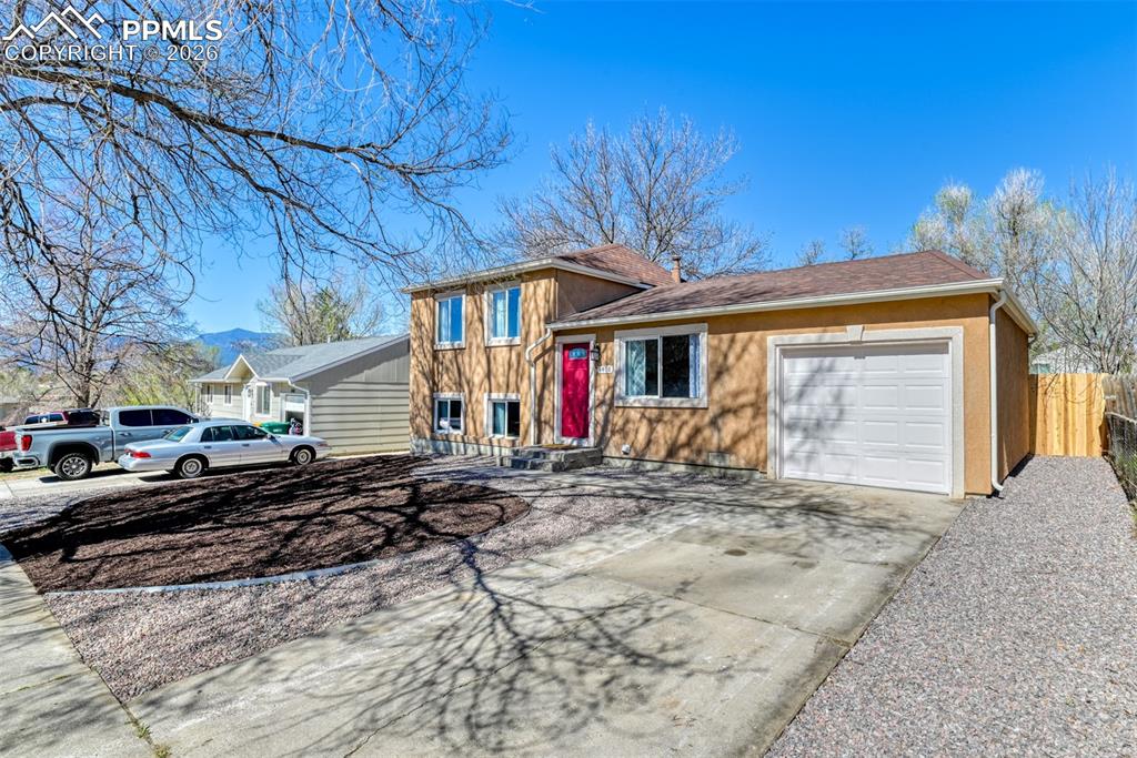 Image 4 of 39: The property features a two-story exterior with a contrasting red front doo