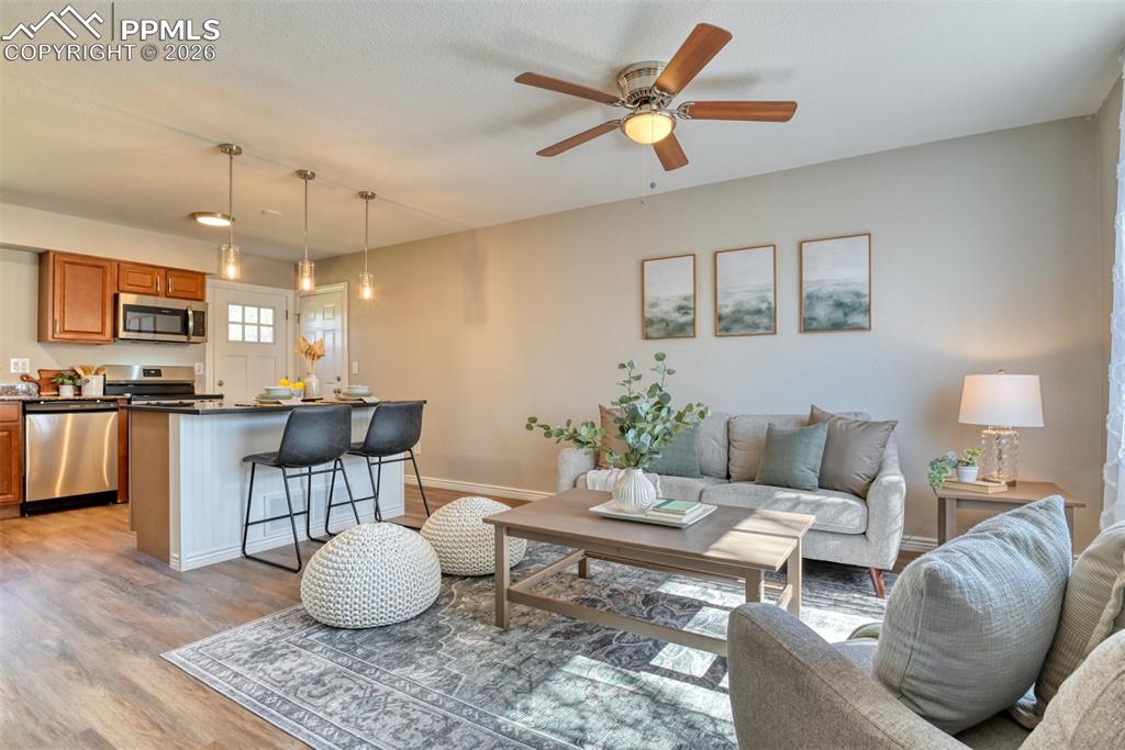 Image 5 of 39: Open concept living area featuring wood-look flooring, a kitchen island wit