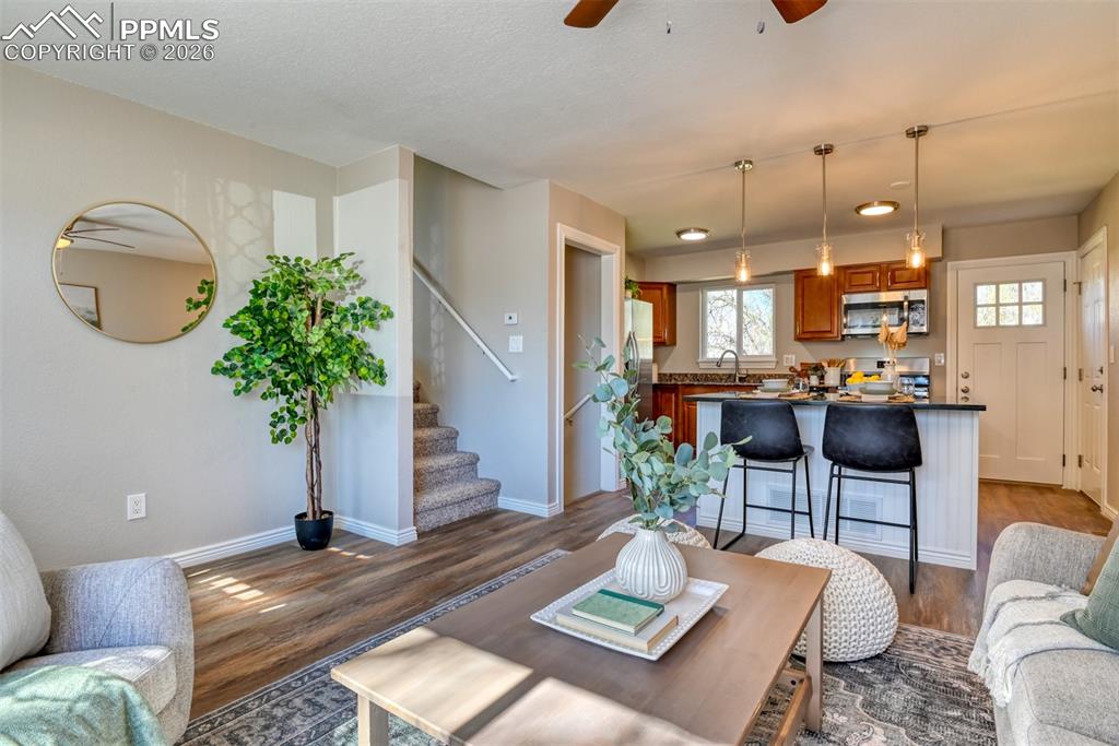 Image 6 of 39: Open concept living area featuring wood-look flooring, a kitchen island wit
