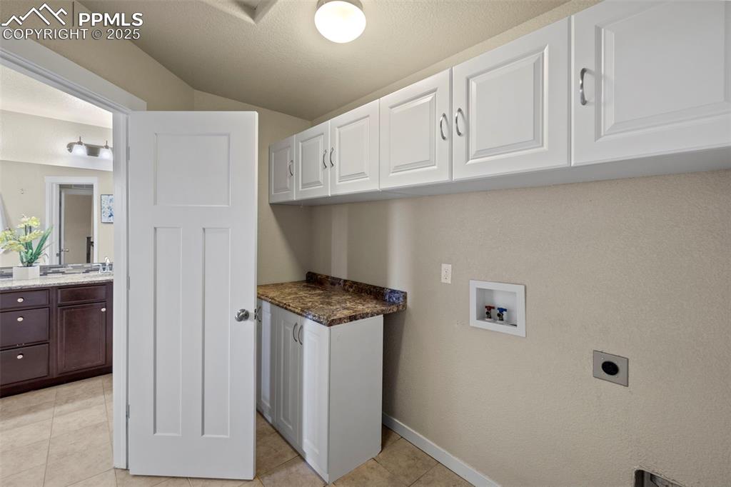 Image 21 of 31: Washroom featuring cabinet space, folding area and washer hookup, hookup fo