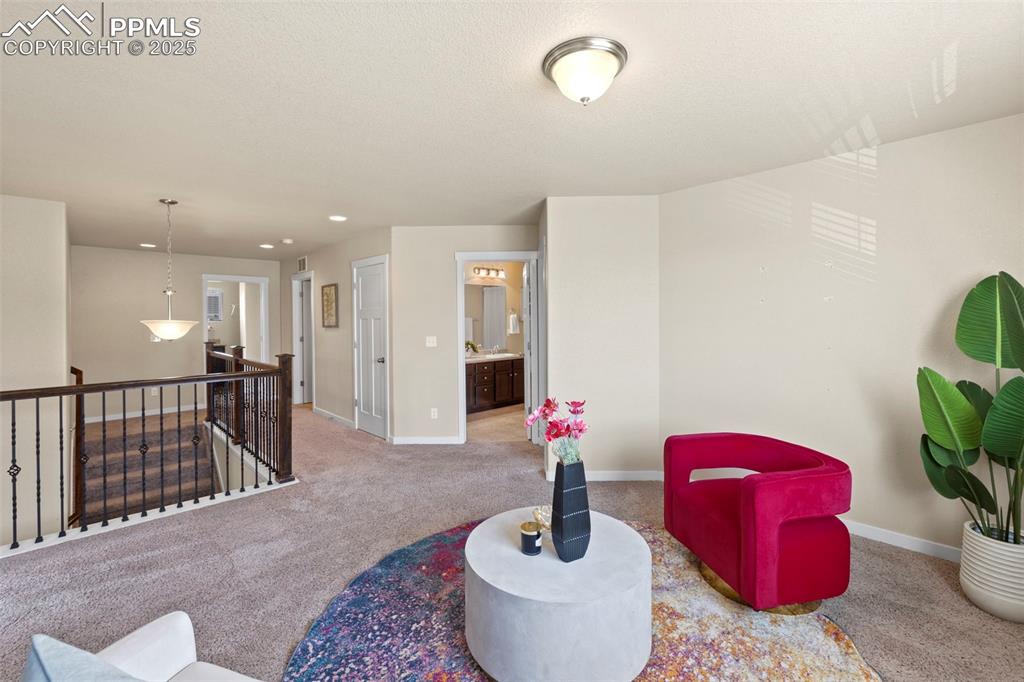 Image 22 of 31: Living area with an upstairs landing, carpet, and recessed lighting